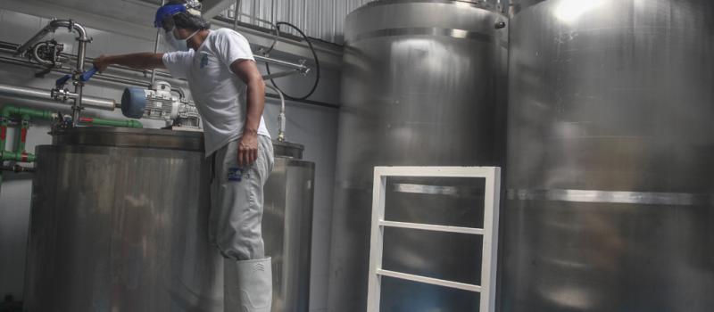 El trabajador José Arias labora en los tanques de procesamiento de los lácteos. Usa todas las protecciones de bioseguridad.